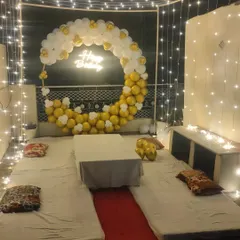 Another view of the cozy terrace cabana setup, showing the white and gold balloon moon backdrop and intimate seating arrangement.