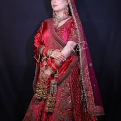 A full view of a magnificent red velvet bridal lehenga. This piece is heavily embroidered and paired with traditional kalire, embodying the classic Indian bridal aesthetic for a grand wedding ceremony.