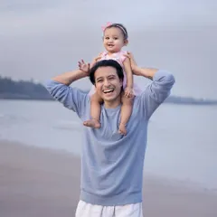 A father's joy, lifting his daughter onto his shoulders for a perfect view of the ocean. These are the playful, happy memories that make for the best family photos.
