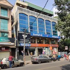 The original building facade, with its dated glass and stone cladding, before we began our transformation.