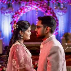 An intimate, over-the-shoulder shot capturing the connection between the couple. The soft lighting and colorful background create a romantic, cinematic feel.