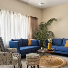 A perfect example of a comfortable and chic living room. We paired bold blue sofas with neutral walls and a jute rug to create a space that feels both vibrant and grounded, with plenty of natural light.