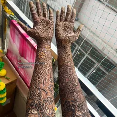 This is a full coverage bridal mehendi design, extending all the way up the forearms. The pattern is dense with floral and paisley elements, perfect for a traditional wedding look.
