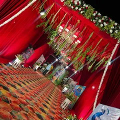 The entrance to the Radha Ashtami celebration was designed to welcome guests into a sacred space. Red drapes, floral borders, and a gallery of religious paintings set a devotional tone right from the start.