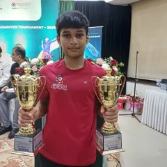 Mayuresh Bhutki holding his two winner's trophies from the Yonex-Sunrise Ramsheth Thakur Trophy Konkan Region Badminton Tournament.