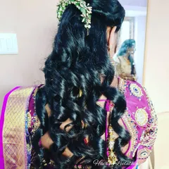 A modern take on event hairstyling. This look features soft, voluminous curls and a delicate floral hair accessory, perfect for a reception or engagement.