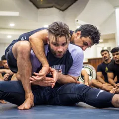 A student practicing a back-take during the BJJ seminar. This is hands-on learning, drilling the techniques shown by the expert instructor.