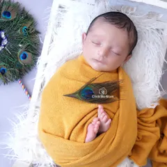 Celebrating little Krishna with all the traditional elements. Here, our baby Kanha is swaddled in auspicious yellow, with a peacock feather and his tiny feet peeking out.