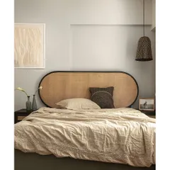 This guest bedroom is defined by its calm and soothing atmosphere. The textured rattan headboard adds a touch of old-world charm, while the soft beige tones and minimalist decor create a peaceful retreat for visitors.