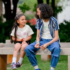 Capturing the special connection between sisters. This candid shot shows a moment of shared conversation and friendship during their outdoor portrait session.