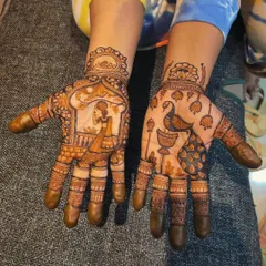 Here is another take on the Karwa Chauth theme, with a woman looking at the moon on one hand and a peacock on a decorated stand on the other. The intricate finger details and wristbands tie the two distinct designs together.