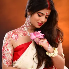 A creative and traditional Bengali look for a themed photoshoot. This features classic eye makeup with a red bindi, paired with intricate white and red Alpona body art on the neck, shoulder, and arm, demonstrating my skill in artistic and cultural makeup.