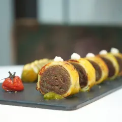 A closer view of our baked paneer rolls, showcasing the intricate layers and the dollop of cream that balances the flavours. It’s a dish that is both classic and new.