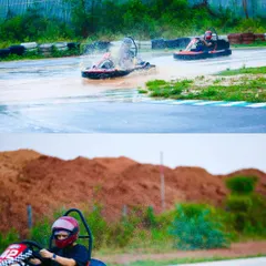 Two karts battling it out in the rain. One driver kicks up a spray of water while the other carefully navigates the slick surface behind.