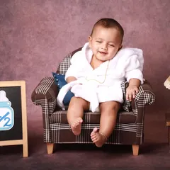 A heart-melting smile captured during the six-month photoshoot. The relaxed setting with the mini armchair allows babies to be comfortable and show off their happy personalities.