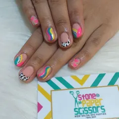A burst of color on natural nails. This design features rainbow swirls, dalmatian spots, and bright color blocks, showing how much fun you can have even without extensions.