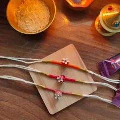A set of three delicate floral rakhis from my 2024 collection. Each one is handmade with colourful thread and a small flower charm.