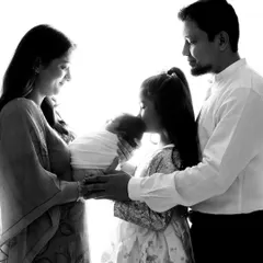 Your first portrait as a new family is a treasure. I always encourage parents and siblings to join the session to capture the complete story of love and connection. This beautiful high-contrast, black and white family portrait freezes a moment of pure adoration.