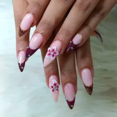 We specialize in 3D nail art. Here, we've combined a sharp stiletto shape with intricate, hand-sculpted acrylic flowers and sparkling rhinestones for a truly custom design.