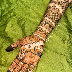 This full-arm bridal design showcases a beautiful flow from hand to elbow. The palm features elegant peacock and floral motifs, while the arm is adorned with bands of geometric and traditional patterns.