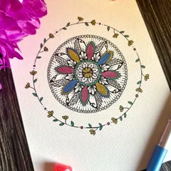 A floral mandala surrounded by a delicate, hand-drawn vine. The mix of colors and patterns in this piece creates a feeling of growth and gentle beauty.