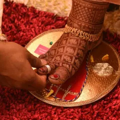 A beautiful shot of a bride's feet during a wedding ritual. The design features a lotus grid pattern, which looks stunning with traditional anklets.
