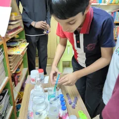 A young scientist carefully uses a syringe to measure liquids for a protein analysis experiment. These activities teach precision, observation, and the scientific method.