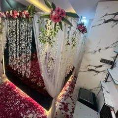 An angled view of the decorated room, showing the hanging floral canopy, draped curtains, and the romantic lighting under the bed.