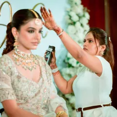 A focused moment, ensuring the maang tikka is perfectly placed and the hairstyle is secure. It's these little details that make a big difference.
