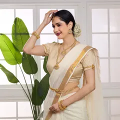 A model in a traditional South Indian look, wearing a full gold temple jewellery set against a clean, indoor backdrop, highlighting the cultural richness of the design.
