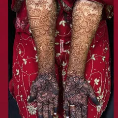 The beautiful dark stain of a full bridal design, set against the bride's red dress. The contrast is absolutely stunning.