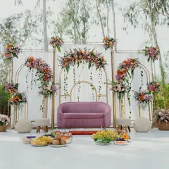 A pastel-themed stage for a half-saree ceremony, complete with traditional offerings beautifully arranged in front.