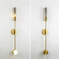 This elegant new wall sconce features a slim brass rod with a glass tube light on top and a soft accent light at the bottom. Its modern, sophisticated design is perfect for adding a touch of class to hallways or beside a mirror.