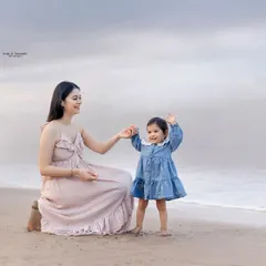 A sweet mother and daughter moment on the beach. We encourage play and interaction to capture authentic smiles and connections during our family beach photography sessions.
