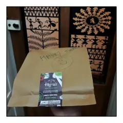 A happy meal, packed in a two-layered bag with a personal touch, ready for delivery. The Warli art in the background is a nod to the traditional roots that inspire my cooking.
