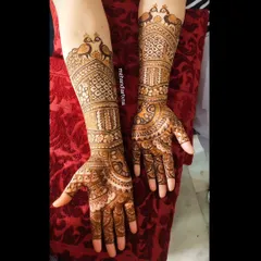 A gorgeous Karwa Chauth design with traditional peacock motifs at the top of the arm, flowing into detailed patterns down to the fingertips.
