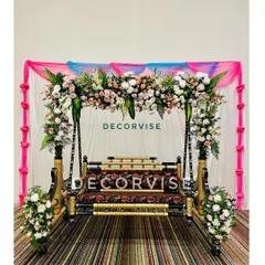 The traditional swing, or jhoola, is the heart of many baby showers. Here, we've decorated it with beautiful arrangements of fresh roses and lilies, set against a simple draped backdrop to make the floral work stand out.