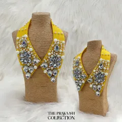 Instantly transform any outfit with our detachable statement collars. This piece, shown in both adult and child sizes, features a vibrant yellow base adorned with large faceted crystals and delicate pearls for a truly glamorous look.