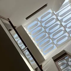 The intricate patterns created by a decorative skylight grill, viewed from below. This feature turns the ceiling into a canvas for light, casting beautiful, artistic shadows.
