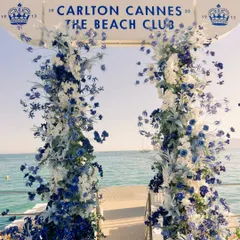 The entrance to the welcome dinner at the Carlton Cannes Beach Club, featuring a magnificent floral arch in shades of blue and white that perfectly framed the sea.