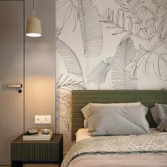 A close-up of the bedside, highlighting the custom headboard mural, minimalist pendant light, and the texture of the wall finish.