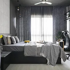 This bedroom showcases the power of a monochrome palette. We layered various shades and textures of grey, from the concrete-finish wall and fluted panels to the soft furnishings, creating a sophisticated and calming atmosphere that remains visually interesting.