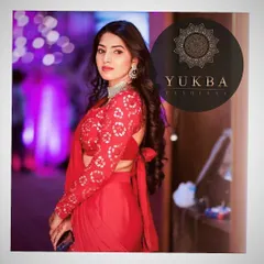 A stunning shot of the client in her red lehenga-saree. The full-sleeved blouse with its tie-back detail makes for a chic and fashionable statement.
