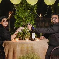 Following the proposal, we documented the couple's private celebration. This shot shows them toasting to their future at a beautifully arranged, candlelit dinner table.