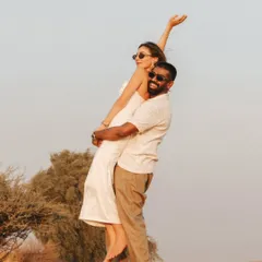 A joyful lift against the clear desert sky, capturing a moment of pure happiness and carefree love during their destination pre-wedding shoot.