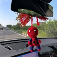 A clear shot of the crochet Spiderman car charm. You can see the detailed stitch work on his suit and eyes. It's a perfect accessory for any Marvel fan.