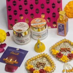 A luxurious Diwali hamper featuring my handmade skincare products. This set includes a Mud Face Pack, Apricot Scrub, and Abhyanga oil, paired with decorative 'Shubh Labh' hangings and a modak candle.