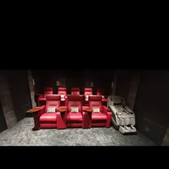 A view of the tiered seating arrangement in a private cinema, featuring vibrant red recliners that offer both style and ergonomic comfort for long viewing sessions.