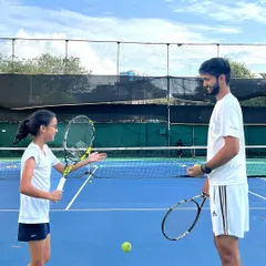 The relationship between a coach and a player is built on trust and communication. I believe in creating a positive environment where students feel understood and motivated. Here, I'm discussing technique with a young player during a training session.
