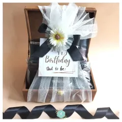 The final look of the "Dad to be" hamper. It's wrapped in delicate white tulle with a flower and a personal tag, making it look as good as it feels to receive.